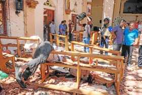 Agentes de la Policía investigan en el interior de la iglesia de San Sebastián, en Negombo. 