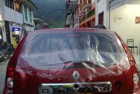 La mujer rompió con una roca el vidrio de este carro. Por el momento, el dueño le adecuó un plástico.