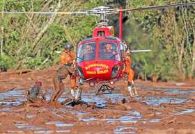 Bomberos sacan un cuerpo durante las labores de búsqueda y rescate de las víctimas de la rotura de la represa de la compañía Val