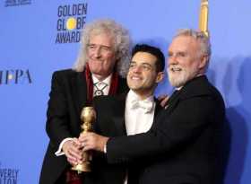 Los miembros de la banda musical Queen Brian May (i) y Roger Taylor (d) posan junto al actor estadounidense Rami Malek 