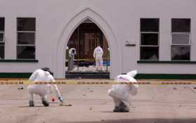 Peritos forenses inspeccionan el lugar donde un carro bomba causó una explosión este jueves en la Escuela General Santander de l