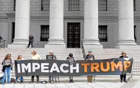 Foto | EFE | LA PATRIA  Manifestantes sostienen una pancarta en una protesta durante la audiencia contra la Organización Trump a