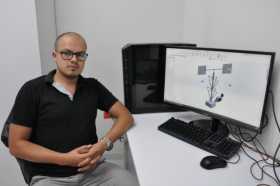 El investigador Carlos Iván Cardona García junto al diseño del Cosechador de Energía