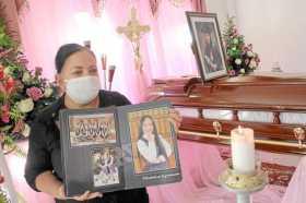 Gloria Riascos sostiene fotografías de su hija Laura Michel Melo Riascos, una de las ocho víctimas de la masacre.