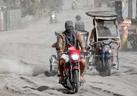 Dos motoristas recorren una carretera cubierta de ceniza, después de la erupción del volcán Taal, en la ciudad de Agoncillo, en 