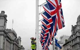 Un hombre iza banderas del Reino Unido en la Plaza del Parlamento en Londres con motivo de la salida de ese país de la Unión Eur