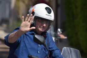 El presidente de Brasil, Jair Bolsonaro, saluda este sábado mientras circula en motocicleta por una avenida de Brasilia (Brasil)