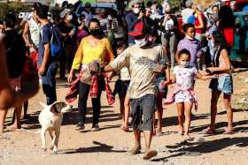 Personas caminando tras recibir una donación de alimentos en la comunidad de Capadócia, en Brasilandia, un barrio en la periferi