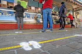 Líneas y huellas dibujadas en el suelo para garantizar la distancia de seguridad entre los clientes que esperan frente a un expe