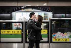 Una pareja se quita las máscaras para besarse mientras esperan el tren, el 24 de febrero de 2020 en Shangái (China). 