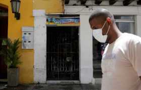 Un hombre camina al frente de una agencia de turismo, este viernes, en Cartagena (Colombia).