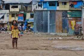 Niños juegan a las afueras de su casa en una barriada de Mumbai (India), donde el cambio climático y la pandemia pueden empujar 
