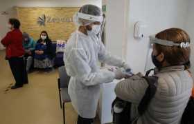 Enfermero toma la temperatura de una paciente que ingresa a la clínica Zerenia en Bogotá.