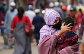 Una mujer con una mascarilla sostiene a su hijo en Bangalore, India, este 7 de septiembre del 2020.