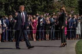 El presidente de los Estados Unidos, Donald J. Trump, y la primera dama, Melania Trump, saludan a los partidarios mientras cruza