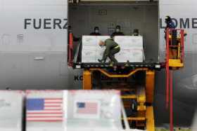 Integrantes de la Fuerza Aérea de Colombia desembarcan un cargamento de vacunas que llegaron desde Estados Unidos hoy a Bogotá