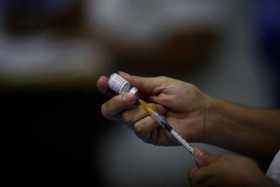Personal médico prepara una dosis de la vacuna Pfizer contra la covid-19, en el Centro Educacional Básico Ricardo Miró, en Ciuda