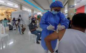 Una enfermera aplica una dosis de una vacuna contra la covid-19 durante una jornada de vacunación masiva en centros comerciales,