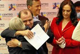 Óscar Iván Zuluaga abraza a su madre, Carina Escobar, luego de conocer que su partido el Centro Democrático lo escogió como el ú