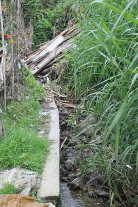 Madera vieja, guaduas y escombros arrojados a un canal que recoge la lluvia de potreros aledaños tienen en alerta a los vecinos.