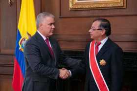 Fotografía cedida hoy por la Presidencia de Colombia que muestra al presidente electo, Gustavo Petro (d) y al presidente salient