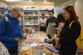 El público asistente a la Feria del Libro observa libros en una de las librerías invitadas