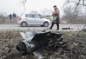 Una mujer mira los escombros de un cohete en la calle después de un bombardeo nocturno en Kiev, Ucrania. 