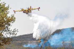 Medios aéreos trabajan en la extinción del incendio declarado en la zona próxima a Casa de Miravete y Deleitosa, ayer en España.