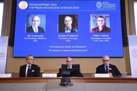 En la pantalla (de izq. a der.) Ben S. Bernanke (EE.UU.), Douglas W. Diamond (EE.UU.) y Philip H. Dybvig (EE.UU.) que reciben el