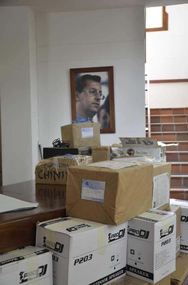 Cajas llenas de libros frente a la imagen de Orlando Sierra