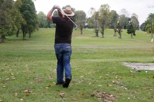 David Bruse, profesor británico que reside en la ciudad, juega golf en el Bosque Popular. Aquí, de espaldas, hace un swing para salir en uno de los nueve hoyos.