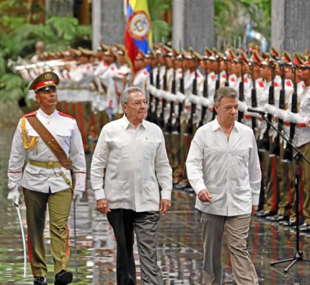 El presidente de Cuba, Raúl Castro y el presidente de Colombia, Juan Manuel Santos, pasan revista a las tropas formadas para la 