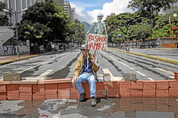Un hombre protesta en Caracas. La oposición venezolana promueve una gran manifestación nacional atrancando las calles y avenidas