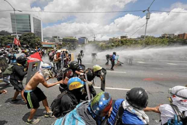 Miembros de la Guardia Nacional se enfrentan a manifestantes opositores en Caracas (Venezuela).