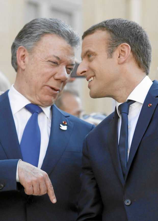 El presidente de Colombia, Juan Manuel Santos, conversa con su homologo francés, Emmanuel Macron, antes de una cena celebrada en
