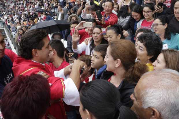 Los asistentes recibieron la comunión haciendo filas en la gradería del escenario deportivo.