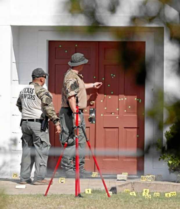 Dos policías observan la puerta tiroteada de la iglesia baptista de Sutherland Springs, Texas, EE.UU.