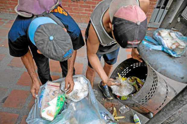 Dos menores hurgan en una basura en busca de comida en una calle de Caracas (Venezuela).
