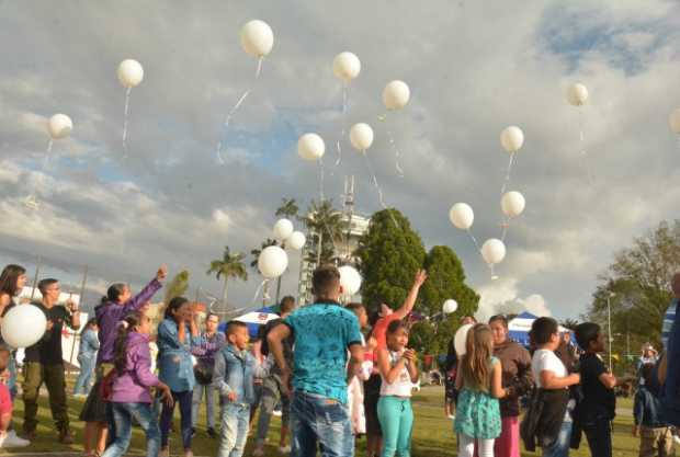 Los niños escribieron un mensaje que amarraron a un globo blanco. Todos lo elevaron al mismo tiempo.