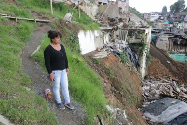 Amparo Beltrán camina por el terreno que quedó en el barrio González después de la tragedia de hace un año, donde murió su hija 