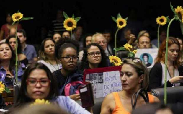 Un grupo de mujeres con girasoles en sus manos participan en la sesión de homenaje que la Cámara de Diputados de Brasil rindió e