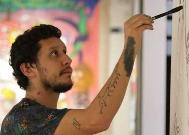 Ricardo Muñoz Izquierdo pintando una figura en la pared.