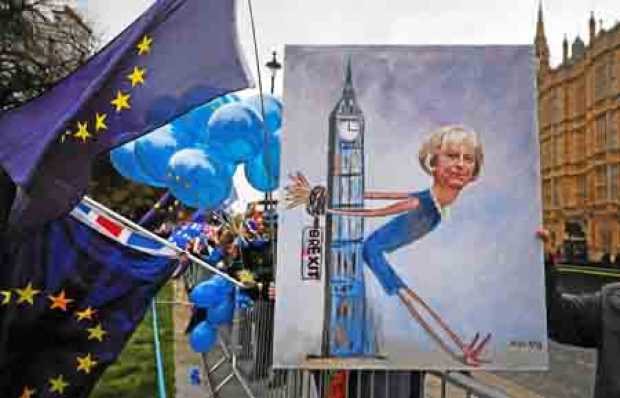 Foto | EFE | LA PATRIA  La artista Kaya Mar muestra un cuadro de la primer ministra británica Theresa May durante una manifestac