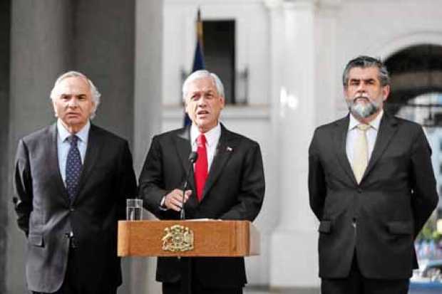 Sebastián Piñera, respaldado por el ministro del Interior, Andrés Chadwick; y el subsecretario de la misma cartera, Rodrigo Ubil