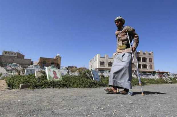 Un yemení herido pasa junto a un cementerio de Saná (Yemen)