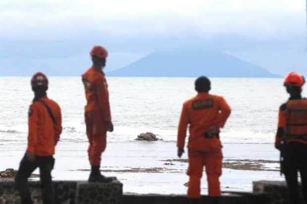 Miembros de los servicios de rescate observan el volcán Anak Krakatau desde la playa Carita en Indonesia