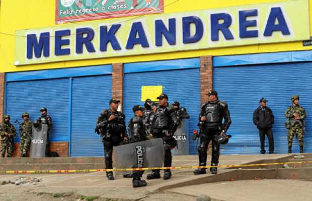 Policías antimotines protegen la entrada del supermercado Merkandrea en el barrio Santa Librada de Bogotá. 