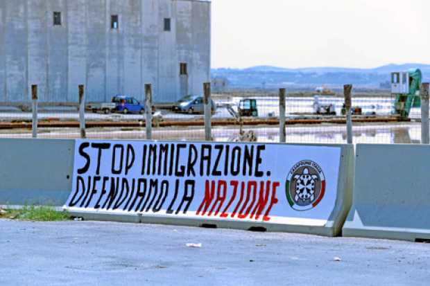 Pancarta con el lema Stop inmigración, defendamos la nación, colocado por la agrupación neofascista CasaPound en el puerto de Tr