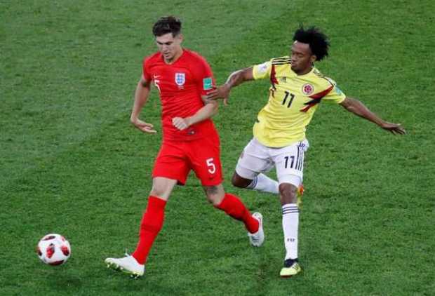 John Stones en una acción de juego con Juan Guillermo Cuadrado. 