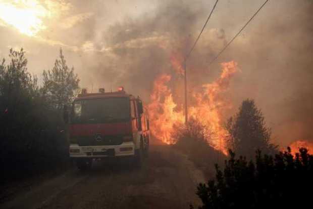  Bomberos tratan de extinguir un incendio en Penteli, al norte de Atenas (Grecia),